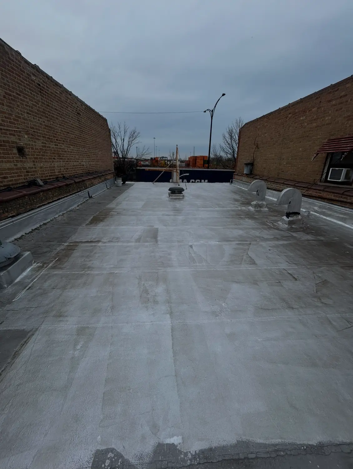 Finished flat roof membrane between two brick parapet walls