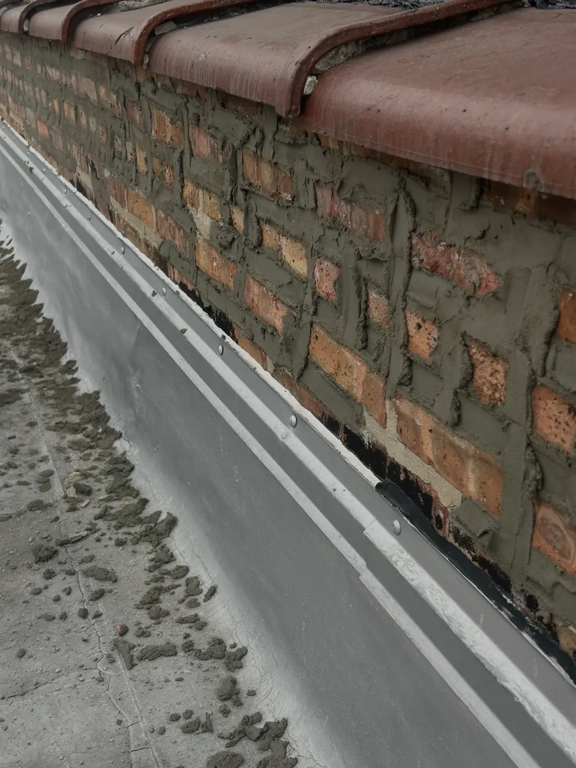 Repointed parapet wall and sealed coping on a flat roof